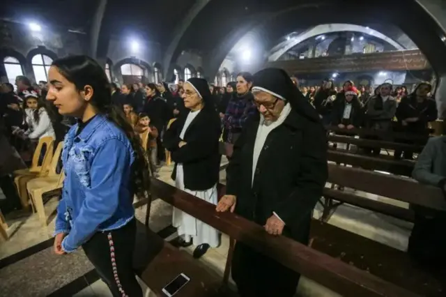مسيحيون خلال قداس عيد الميلاد في كنيسة مار بهنام ومارت سارة للسريان الكاثوليك،في بلدة قرقوش، شمالي العراق في 25 ديسمبر/كانون الأول 2018