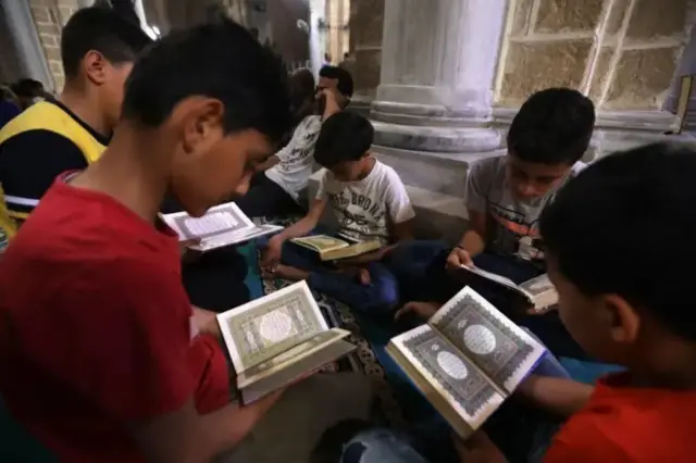أطفال مسلمون في غزة يقرأون آيات قرآنية في أول أيام شهر رمضان في جامع العمري في غزة. 06 مايو/أيار 2019