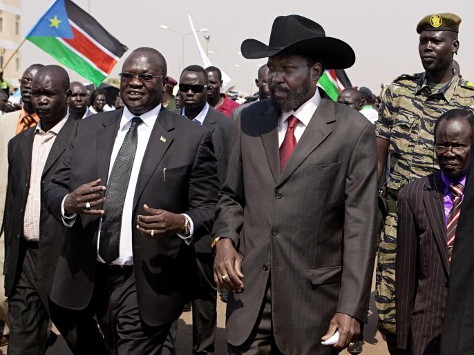 FILE - In this Tuesday, Feb. 8, 2011 file photo, South Sudanese President Salva Kiir, centre-right, is greeted by then Vice-President Riek Machar, centre-left, on Kiir's return to Juba, South Sudan, from Khartoum where he attended the formal announcement of southern Sudan's referendum results. South Sudan President Salva Kiir signed a peace deal with rebels Wednesday, Aug. 26, 2015 in a ceremony witnessed by regional leaders in the capital Juba, after 20 months since the start of fighting between loyalist forces and rebels led by his former deputy Riek Machar. (AP Photo/Pete Muller, File)