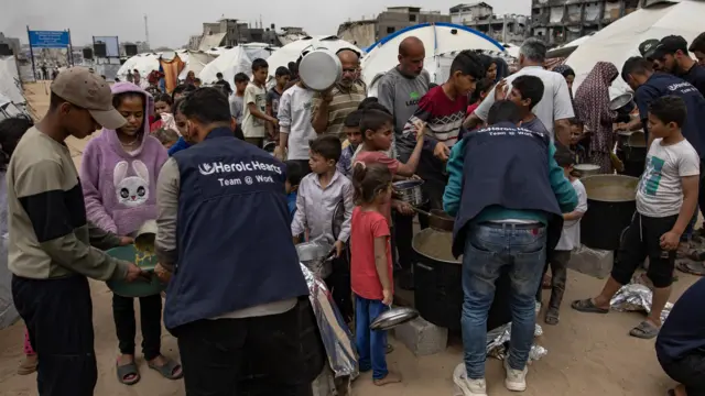 فلسطينيون يتجمعون للحصول على وجبات توزعها جمعيات خيرية في مخيم جباليا للاجئين، شمال قطاع غزة