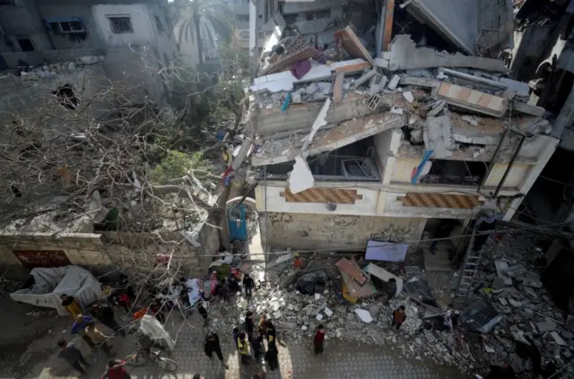 فلسطينيون يتجمعون في موقع غارة إسرائيلية على منزل في جباليا، شمال قطاع غزة، 16 أبريل/ نيسان 2025.  