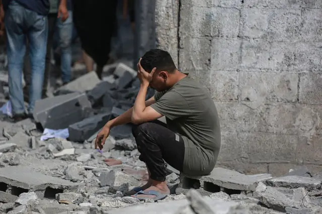 رجل فلسطيني يجلس بالقرب من أنقاض منزل سكني تعرض للقصف الإسرائيلي خلال الليل في جباليا شمال قطاع غزة، في 30 يونيو/حزيران 2025.