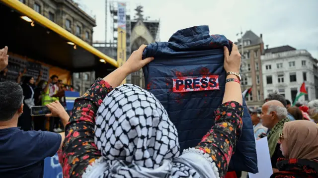 متظاهرة ترفع قميصاً مكتوباً عليه "صحافة" خلال مظاهرة في ساحة السد بأمستردام، هولندا، في 16 أغسطس/آب 2025.